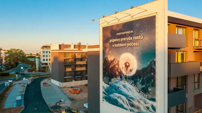 Projekt Púpavy pri Aleji v Trnave s reklamnou plachtou na fasáde nového bytového domu