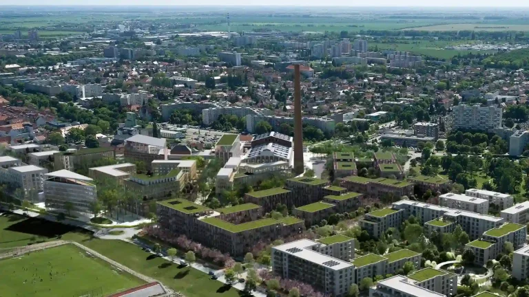 Letecký pohľad na areál bývalého cukrovaru v Trnave, kde vzniká nová mestská štvrť. Vizualizácia ukazuje plánované bytové domy, zeleň, centrálny park a dominantný komín ako pripomienku industriálnej minulosti.