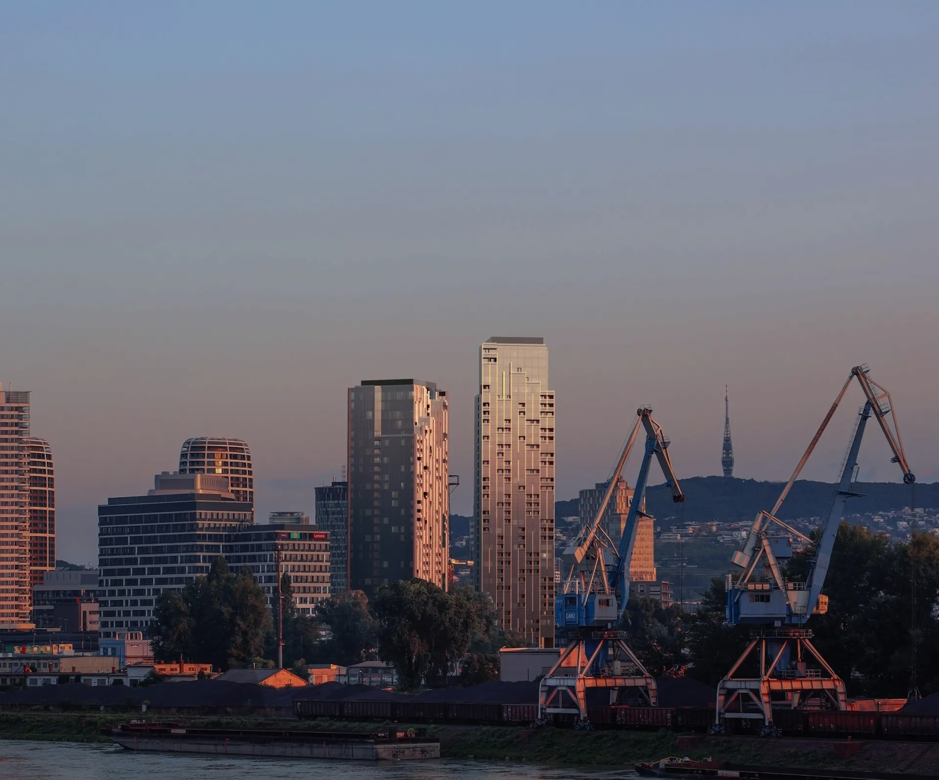 Oficiálny render projektu Portum Towers zobrazuje plánované výškové budovy v zóne Chalupkova. V popredí sú zachytené žeriavy na nábreží Dunaja a v pozadí silueta televíznej veže Kamzík. Návrh kombinuje modernú architektúru s industriálnym charakterom lokality.